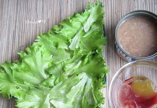 1. Этап. Новогодний салат Тунец и хурма: Листья салата порвите руками, разложите по тарелкам. Смешайте все ингредиенты для заправки.