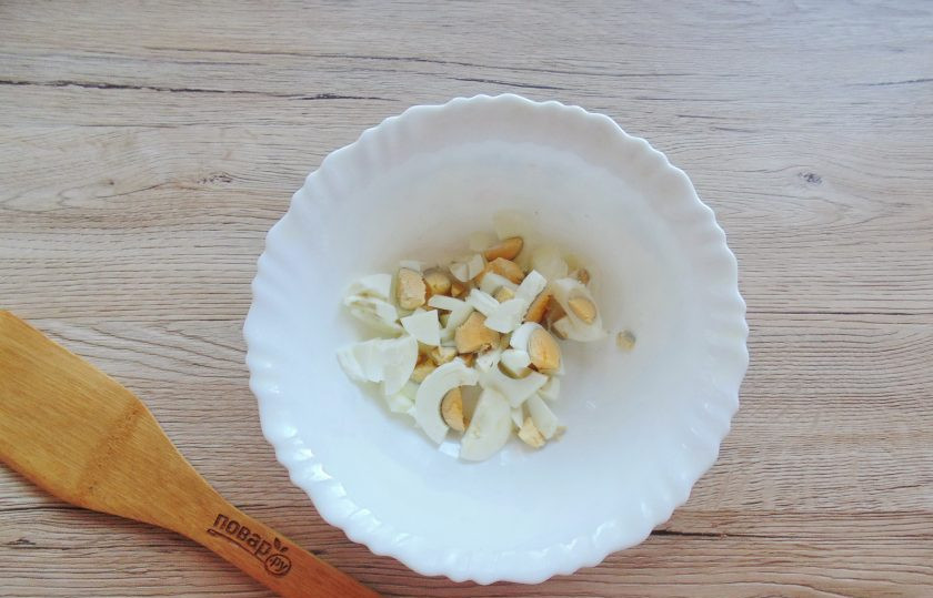 1. Этап. Салат из кабачков с редиской: Яйца отварите вкрутую, остудите и очистите. Нарежьте мелко и выложите в салатник.