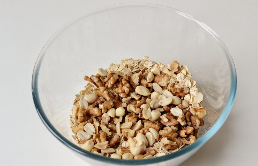 1. Этап. Гранола без сахара: Орехи порубите крупно ножом. Добавьте в миску с овсяными хлопьями.
