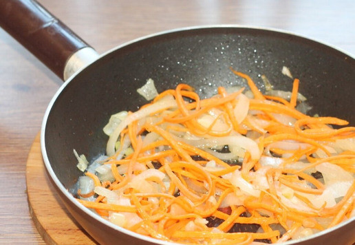 1. Этап. Запеканка с картофелем, кабачками, мясным фаршем: 7. В сковороде разогрейте подсолнечное масло (1-2 ст. л.) и выложите лук. Обжарьте, помешивая, примерно 3 минуты. Затем добавьте морковь и тушите еще 3 минуты.