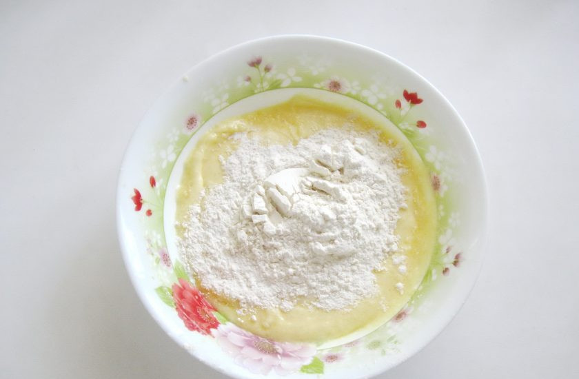 1. Этап. Апельсиново-шоколадный кекс: Постепенно всыпьте в миску муку. Перемешайте до однородной, гладкой консистенции.