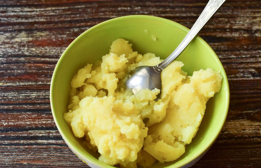 1. Этап. Картофельные рогалики: Отварной картофель подавите толкушкой.