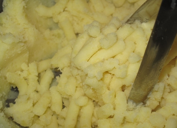 1. Этап. Картофельное пюре с жареным луком: Пока кратофель ещё тёплый, добавьте в него молоко и, включив медленный огонь, вскипятите молоко. Затем при помощи специальной толкушки превратите картофель в пюре. При необходимости посолите.