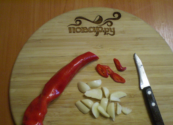 1. Этап. Закатка огурцов в литровые банки: Режем чеснок и перец чили.