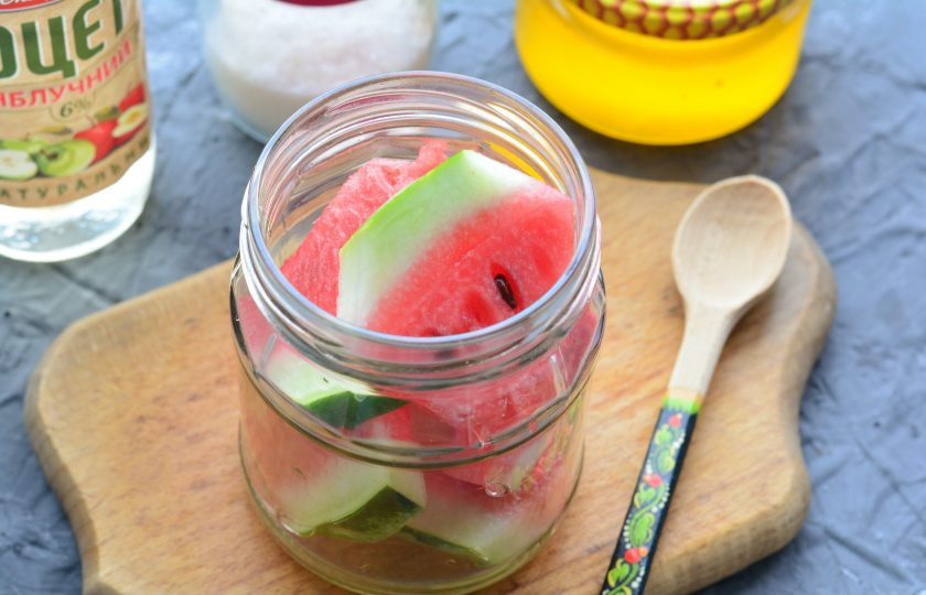 1. Этап. Арбузы маринованные с медом: Нарежьте арбуз небольшими кусочками вместе с кожурой и выложите в чистые простерилизованные баночки.