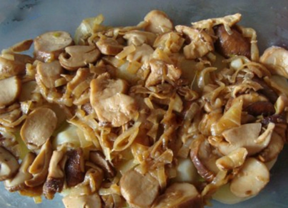 1. Этап. Картофель, запеченный с мясом и грибами: 4. Возьмите глубокое блюдо для запекания, смажьте его с внутренней стороны небольшим количеством растительного масла. Выложите слой из сваренной картошки, нарезанной дольками. Далее выложите слой зажарки из репчатого лука и грибов. Сверху равномерно полейте сливками.