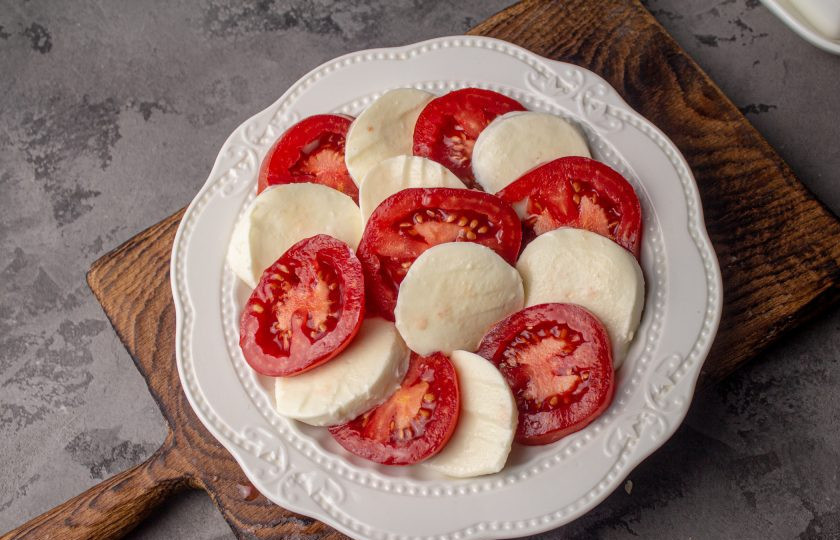 1. Этап. Закуска с сыром Моцарелла: На плоскую тарелку выложите поочередно слегка внахлест помидоры и сыр.