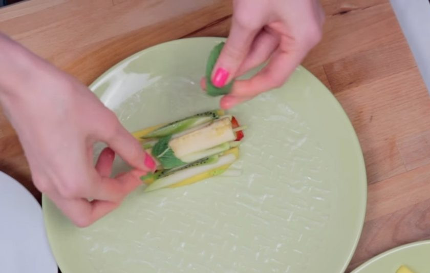 1. Этап. Фруктовые спринг-роллы: 3. Аккуратно заверните рисовую бумагу в форме ролла и выложите на тарелку так, чтобы роллы не соприкасались друг с другом.