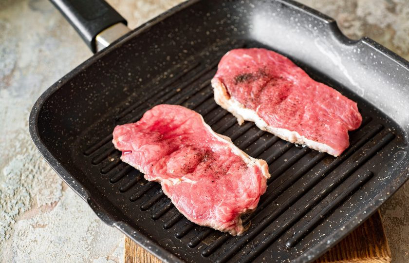 1. Этап. Нежная говядина под ягодным соусом: Тонким слоем растительного масла смажьте поверхность сковороды-гриль, воспользовавшись силиконовой кулинарной кистью. Поверх каждого стейка посыпьте черным молотым перцем и солью. Обжаривайте стейки на максимальном огне с двух сторон до появления золотистой корочки. У меня ушло на обжаривание каждой стороны примерно по 3 минуты.