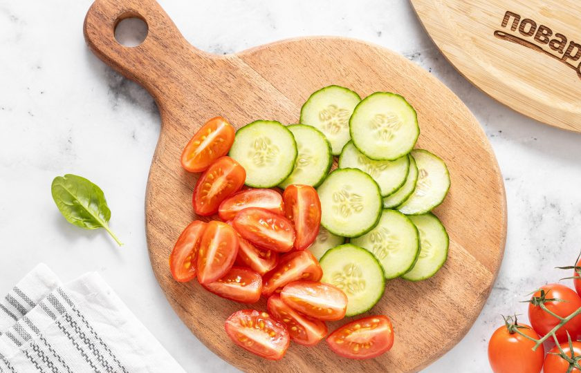 1. Этап. Салат со шпинатом, помидорами и огурцами: Помидоры черри разрежьте на 2-4 части, а огурцы нарежьте кружочками.