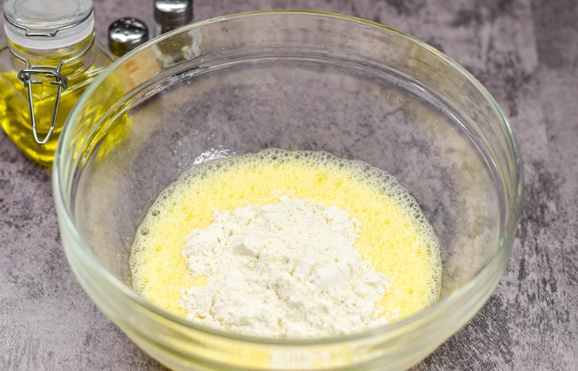 1. Этап. Лук в кляре к пиву: Добавьте к яйцам две столовые ложки пшеничной муки. Снова все взболтайте.