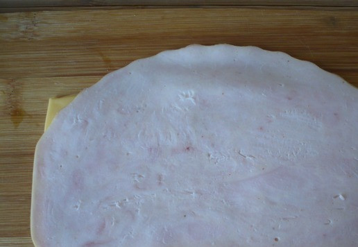 1. Этап. Кубики ветчины и сыра для перекуса: Положите 2 ломтика плавленого сыра рядом друг с другом, поверх положите ломтики ветчины. Повторите слои, пока не израсходуете всю ветчину и ломтики плавленого сыра.