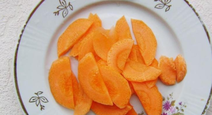 1. Этап. Салат из капусты и огурцов на зиму: Очищенную морковь нарежьте слайсами.