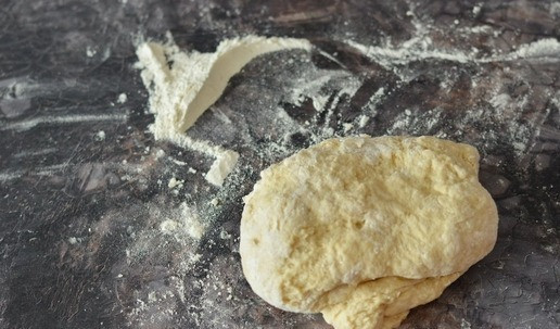 1. Этап. Булочки сахарные из ночного теста: Затем слегка подпылите стол мукой и вымесите тесто на столе. Будьте готовы к тому, что количество муки может отличаться в ту или иную сторону. Поэтому ориентируйтесь не только на указанную граммовку, но и на консистенцию теста. Оно должно быть мягким, как щёчка младенца, но при этом не липнуть к рукам.