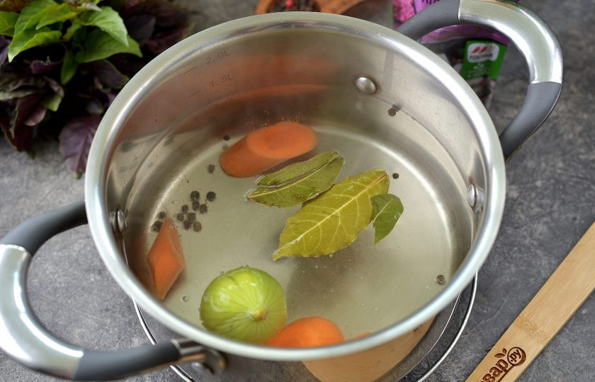 1. Этап. Язык отварной с хреном: Вскипятите в кастрюле воду, выложите в нее лавровый лист, перец горошком, нарезанную крупными ломтиками морковь и надрезанный крестообразно лук. Воду хорошенько посолите.