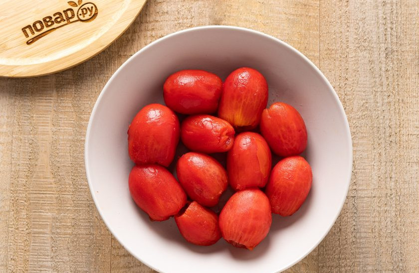 1. Этап. Баклажаны 5 овощей на зиму: Затем опустите в холодную воду. Удалите плодоножку и очистите их от шкурки. Далее томаты может разрезать пополам или оставить целыми.