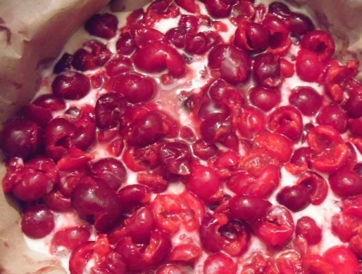 1. Этап. Пирог из жидкого теста: 5. Форму для запекания смажьте маслом или застелите пергаментом. Вылейте в неё примерно половину теста. Распределите начинку. В данном случае - это вишня.