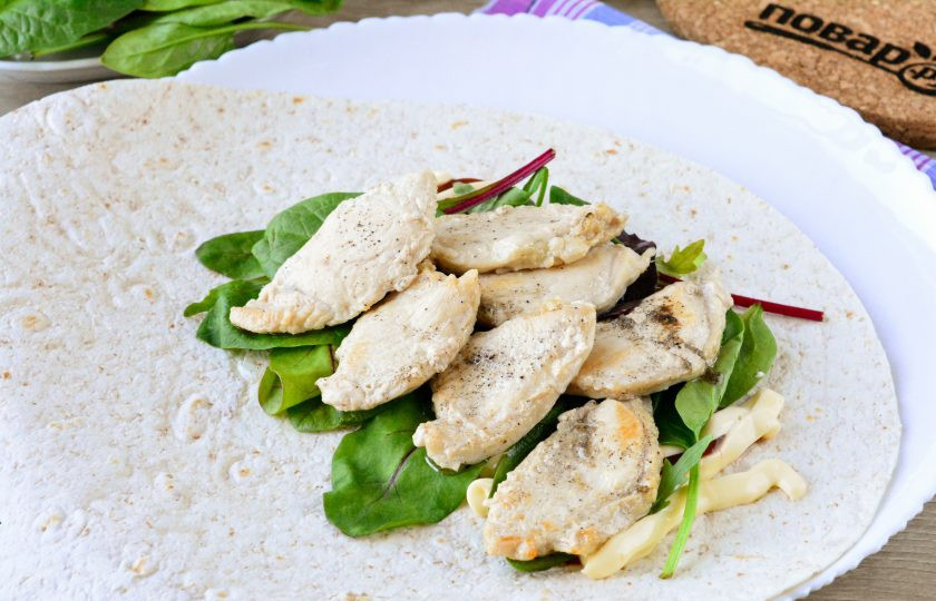 1. Этап. Шаурма в лепешке по-домашнему: Распределите всю вымытую и хорошо просушенную зелень, добавьте сверху кусочки обжаренной курицы.