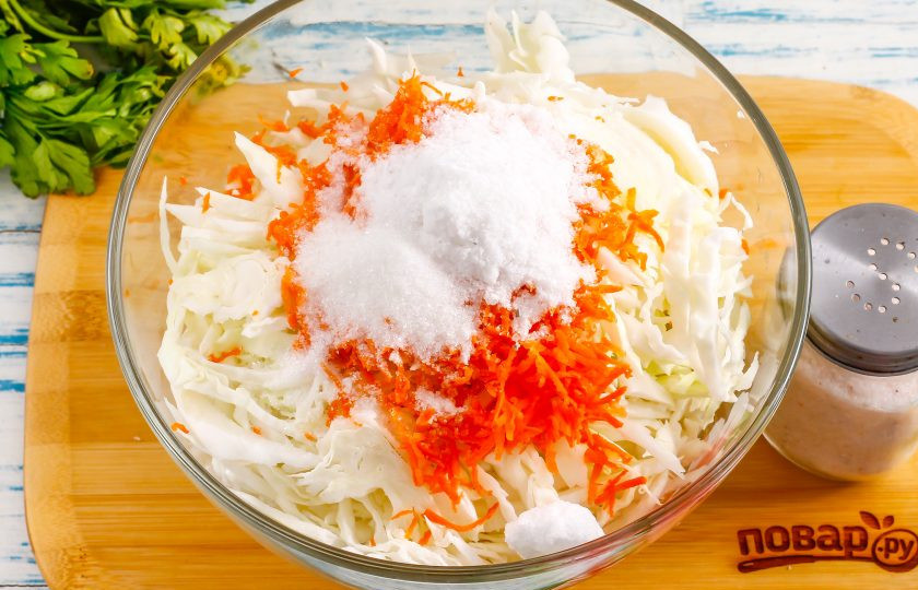1. Этап. Квашеная капуста как на рынке: Очистите морковь от кожуры, промойте в воде и натрите на терке с мелкими ячейками в емкость. Всыпьте соль и сахарный песок.