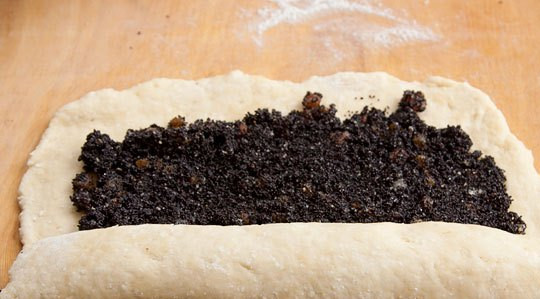 1. Этап. Рулет с маком без дрожжей: Замесив тесто, раскатываем его прямоугольным пластом на столе, в центр кладем начинку и сворачиваем его рулетом.