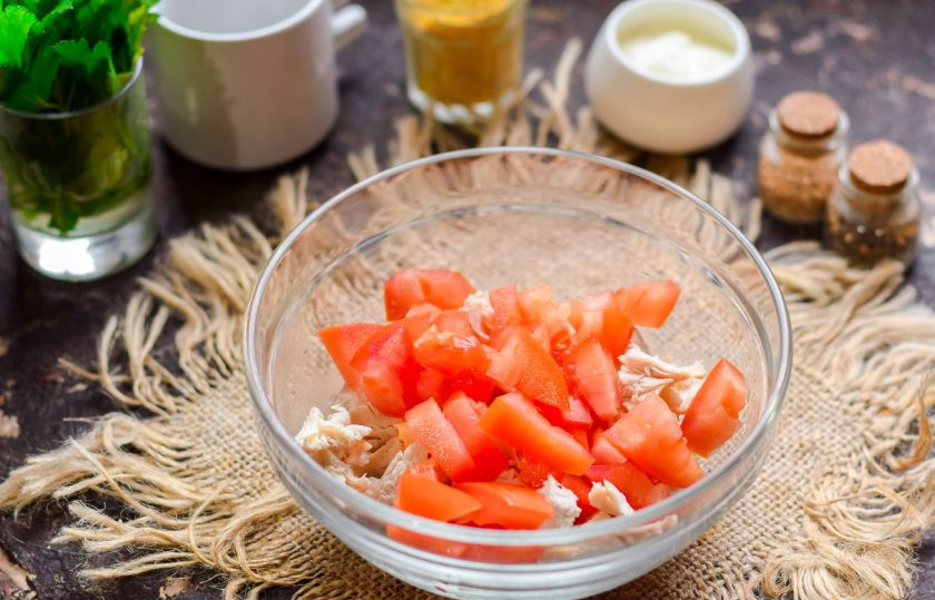 1. Этап. Салат с курицей и помидорами: Помидоры сполосните и просушите, нарежьте небольшими кубиками. Переложите помидорную нарезку в салатник к куриному филе.