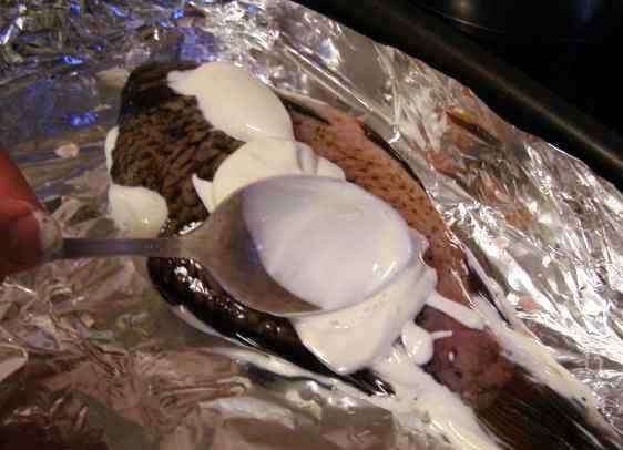 1. Этап. Карась в сметане: Непосредственно в противне проделываем аналогичную процедуру со второй стороной карася: смазываем сметанкой, посыпаем специями.