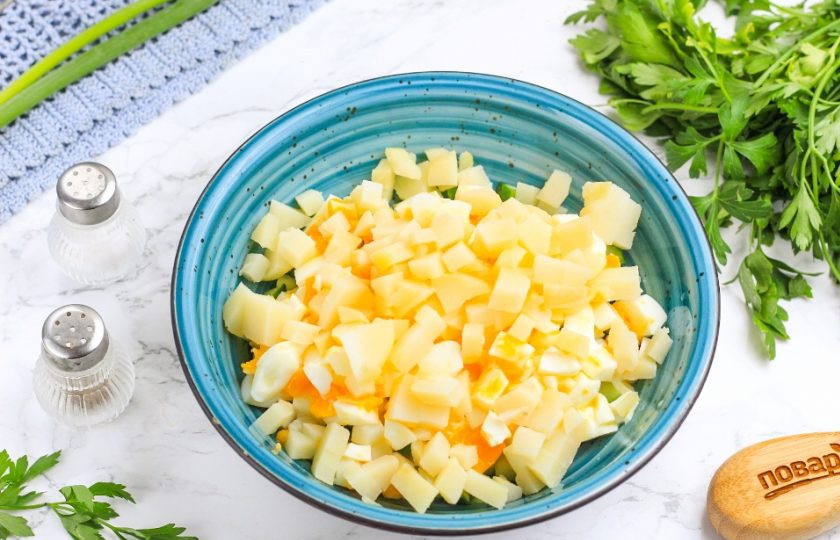 1. Этап. Салат с масляной рыбой: Такими же кубиками нарежьте отварные куриные яйца и картофель. Добавьте в емкость к огуречной нарезке. По желанию можете использовать специальный кухонный гаджет.