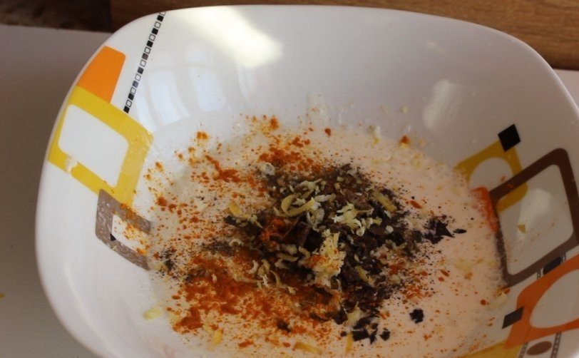 1. Этап. Кролик в сметанном соусе в мультиварке: Сделайте соус, смешав измельчённый чеснок со сметаной, перцем, цедрой, куркумой, солью и базиликом.