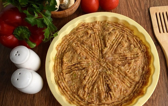 1. Этап. Диетическая куриная пицца без теста: Выложите мясной фарш в силиконовую круглую форму для запекания, разровняйте. Или можете выложить в виде круглой лепешки на противень, выстланный пергаментом для выпечки. Запекайте в разогретой до 180°C духовке в течение 15 минут.