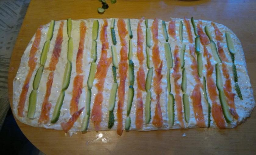 1. Этап. Лаваш с красной рыбой и плавленым сыром: 2. Выкладываем теперь поверх сыра кусочки рыбы и огурцов, добавим немного салатных листьев и зелени, заворачиваем в рулет.