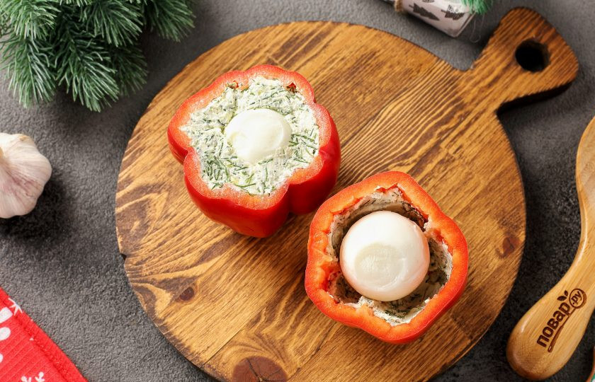 1. Этап. Новогодняя закуска Взгляд дракона: Часть начинки плотно выложите вдоль стенок перца. По центру каждого перца выложите по одному очищенному варёному яйцу. Оставшееся пространство заполните остальной начинкой.