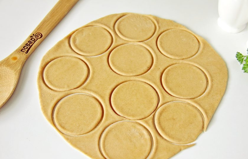 1. Этап. Пельмени из цельнозерновой муки: От теста отрежьте кусок и раскатайте в пласт, толщиной примерно 2 мм. Поверхность стола я ничем не посыпаю, тесто эластичное и удобное в работе. Стаканом или рюмкой (в зависимости от желаемого размера пельменей) вырежьте кружки.