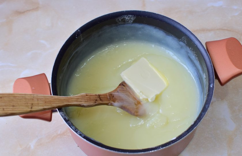 1. Этап. Французский крем для эклеров: Снимите кастрюлю с огня. Добавьте сливочное масло. Оно сразу растает. Вмешайте его в крем. Накройте крем крышкой и дайте ему остыть.