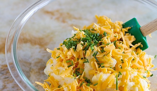 1. Этап. Шампиньоны под шубой: 2. Часть сыра отложите, а остальной сыр соедините с пюре и измельченной зеленью. Тщательно перемешайте.