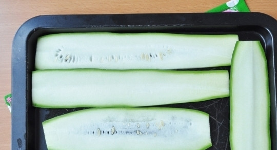 1. Этап. Нежные рулетики из кабачков с куриным филе: Смажьте противень растительным маслом. Духовку разогрейте до двухсот градусов. Затем вымойте и нарежьте кабачок на тонкие кусочки (в длину). Выложите овощ на противень, запекайте семь минут до мягкости.