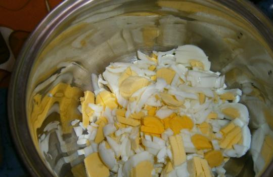 1. Этап. Салат из консервированных кальмаров и шампиньонов: Яйца отварите и порежьте мелкими кубиками, удобно воспользоваться для этого яйцерезкой.