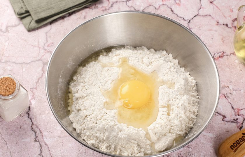 1. Этап. Заварное тесто для вареников: Соедините муку и соль. Добавьте яйцо и растительное масло.