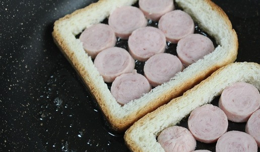 1. Этап. Перекус на сейчас и на потом: На разогретую сковороду с маслом выкладываем хлебные рамки. В них выкладываем колечки сосисок. Немного поджариваем.