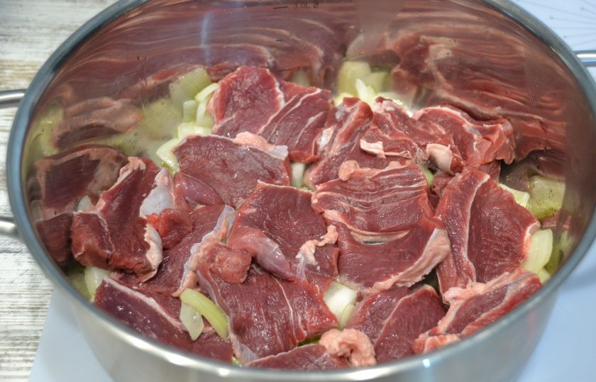 1. Этап. Говядина в перечном соусе: Нарежьте говядину и выложите поверх лука. Продолжайте тушить на небольшом огне, накройте крышкой.