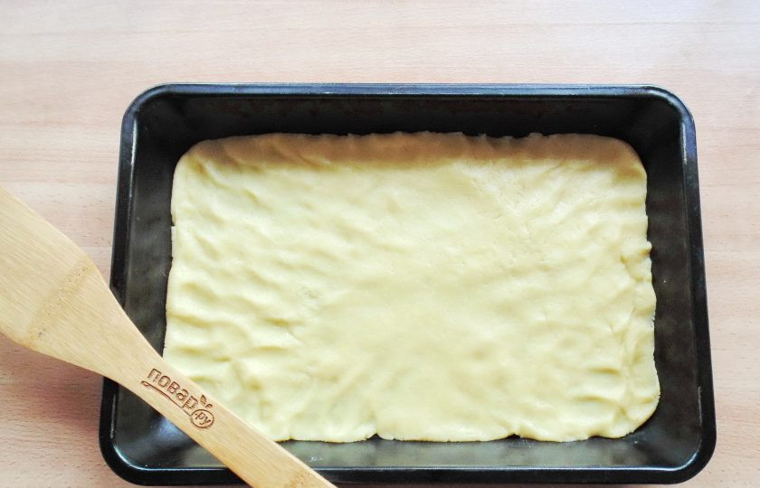 1. Этап. Песочный пирог с малиновым вареньем: Одну треть теста отправьте в морозильную камеру на 10-15 минут. А вторую выложите в форму для выпечки. Размер моей формы 18х28 сантиметров.