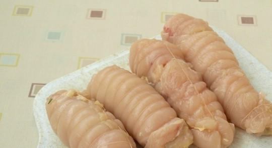 1. Этап. Рулетики из грудки курицы: Сверните каждый кусочек курицы в рулет так, чтобы сыр оказался внутри. Промойте кулинарные нити под водой и тщательно оберните ими получившиеся рулетики.