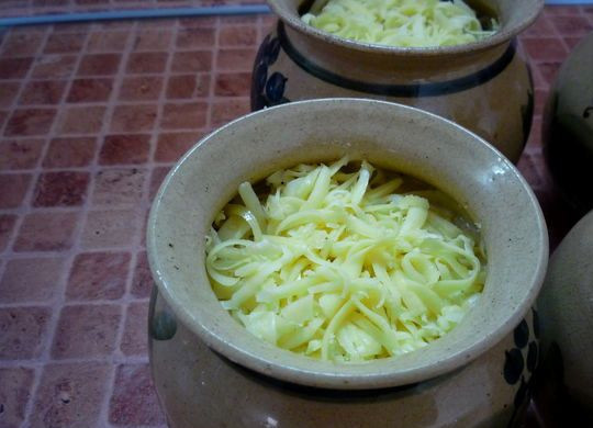 1. Этап. Жульен с картошкой и грибами: Сверху соус обильно посыпаем тертым на крупной терке сыром, ставим горшочки в разогретую до 180 градусов духовку.