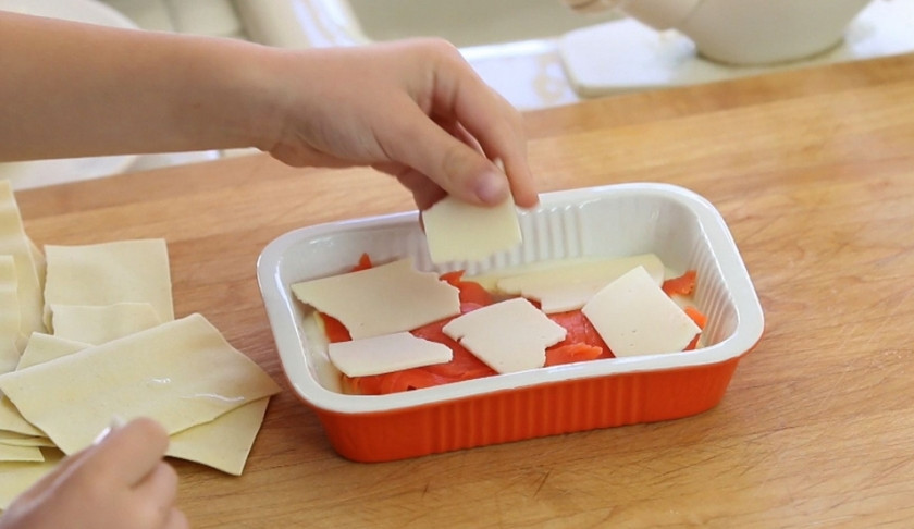 1. Этап. Семга под соусом Бешамель: 4. Собираем теперь наше блюдо. Дно формы смажем маслом, выкладываем на него листы лазаньи, дальше — кусочки рыбки, а сверху — кусочки моцареллы.