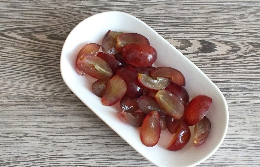 1. Этап. Салат Мадам с курицей и виноградом: Виноград разрежьте на четвертинки и удалите косточки.