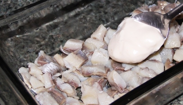 1. Этап. Салат рыбный: 3. В салатник или любое другое глубокое блюдо выкладываю нижним слоем селедку. Смазываю рыбку тонким слоем майонеза.