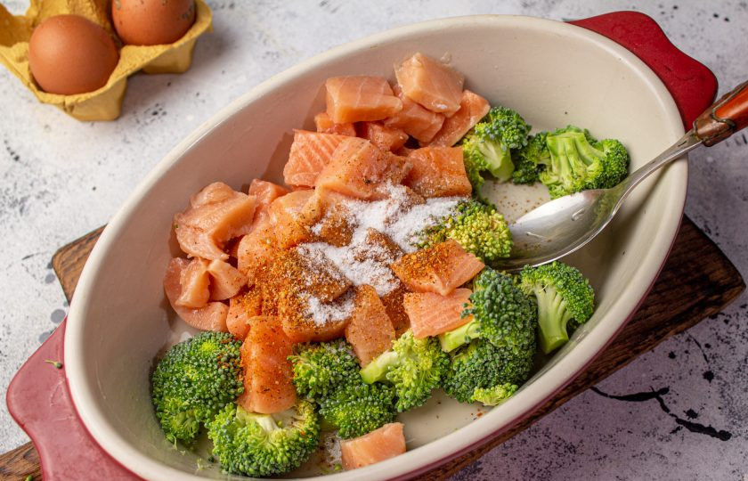 1. Этап. Запеканка с форелью и брокколи: Форму для выпечки смажьте маслом, выложите рыбу и капусту. Посолите и поперчите, перемешайте.