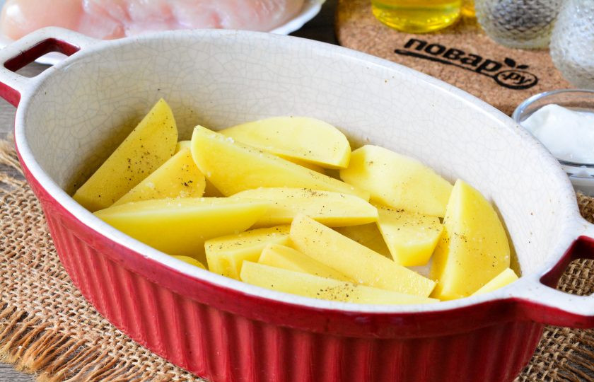 1. Этап. Куриные грудки с картошкой и грибами: Форму для запекания смажьте растительным маслом, первым слоем выложите картофель. Посолите его и поперчите по вкусу.