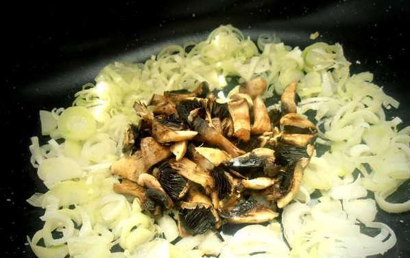 1. Этап. Садж: Выкладываем на сковороду нарезанные грибы и лук-порей и обжариваем, пока из грибов не испарится лишняя влага.