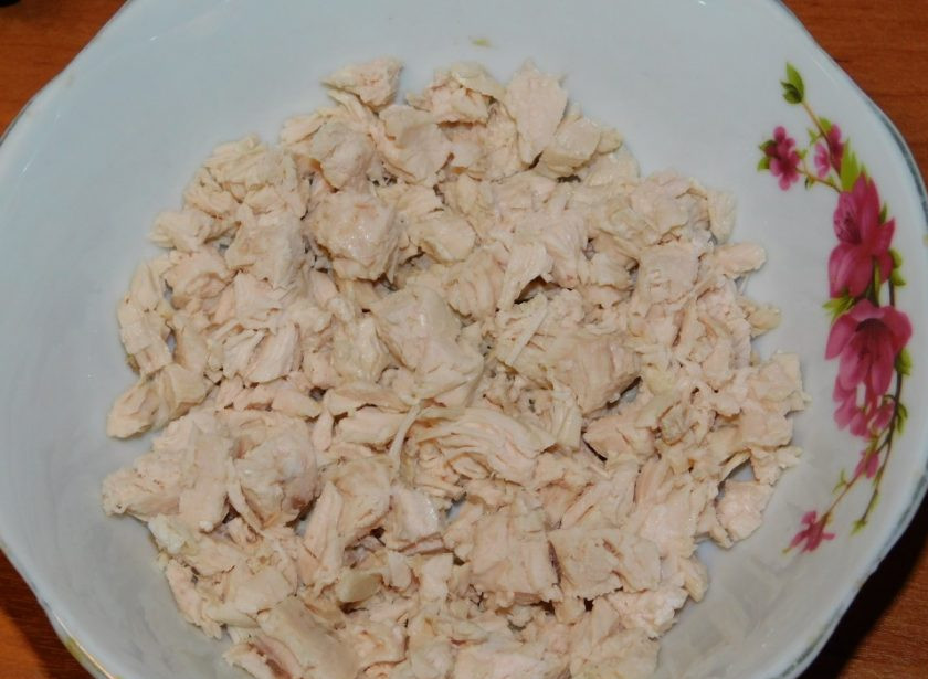 1. Этап. Слоеный салат с черносливом: В салатницу первым слоем выкладываем нарезанное куриное филе. Его предварительно необходимо отварить, остудить и нарезать. Не забывайте каждый слой промазывать майонезом.