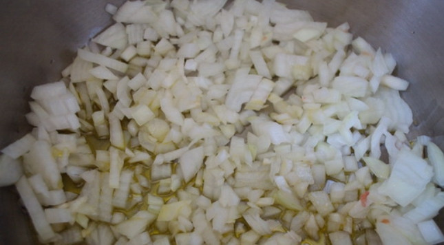 1. Этап. Баклажанная икра на зиму: 4. Очистите и очень мелко нарежьте луковицу. Разогрейте кастрюлю с подсолнечным маслом и выложите лук, обжарьте его пару минут.